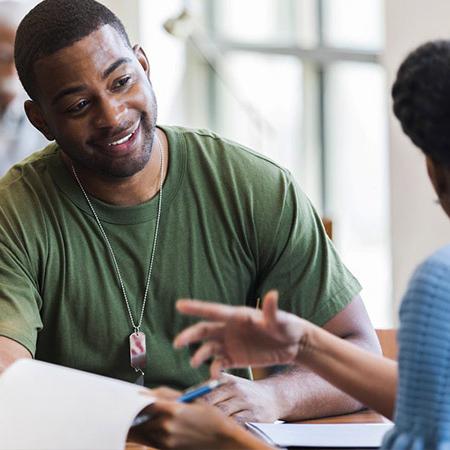 军事 student sitting across a table from an advisor